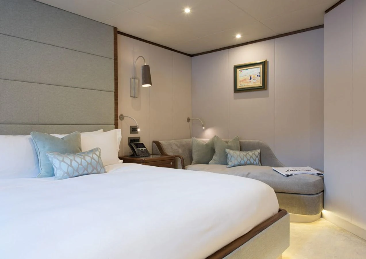 a bed with a white bed spread aboard LADY A Yacht for Sale