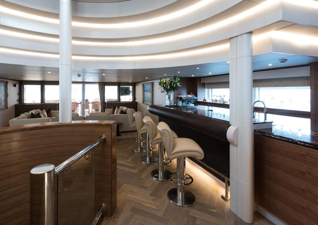a room with a large window and a table with chairs aboard LADY A Yacht for Sale
