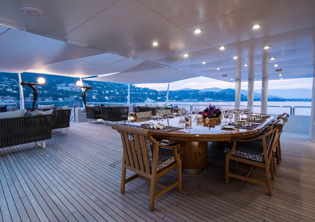 a table with chairs and a large umbrella in a room with a large pool and a table with aboard LADY A Yacht for Sale