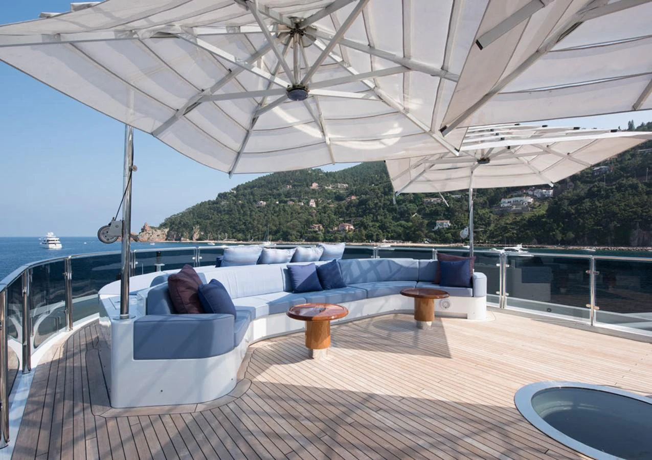 a large lounge area with a large body of water and trees aboard LADY A Yacht for Sale