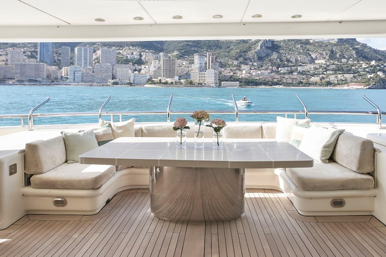 a table and chairs on a balcony overlooking a city aboard SAMIRA Yacht for Sale