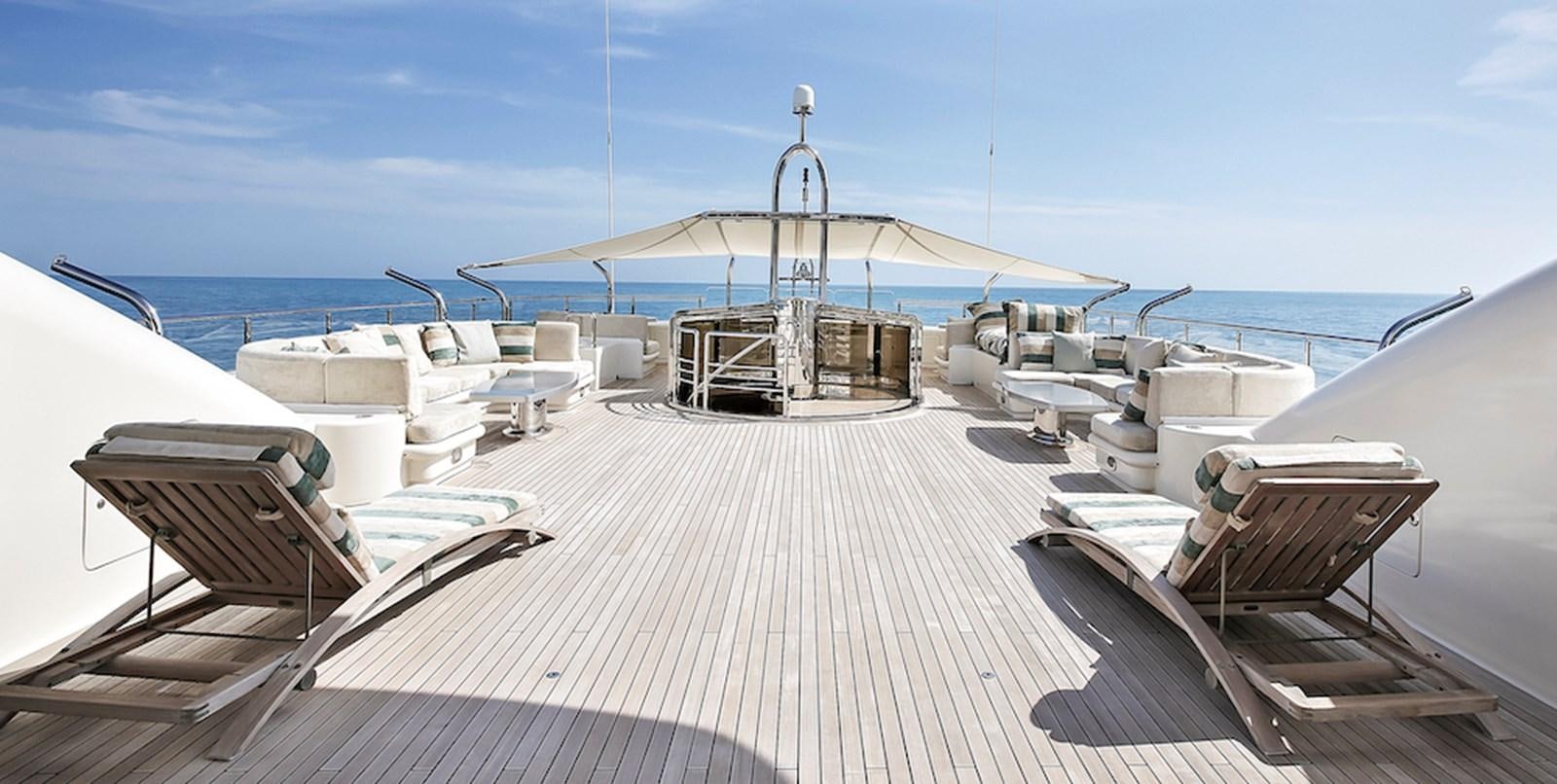 a deck with chairs and a table on it aboard SAMIRA Yacht for Sale
