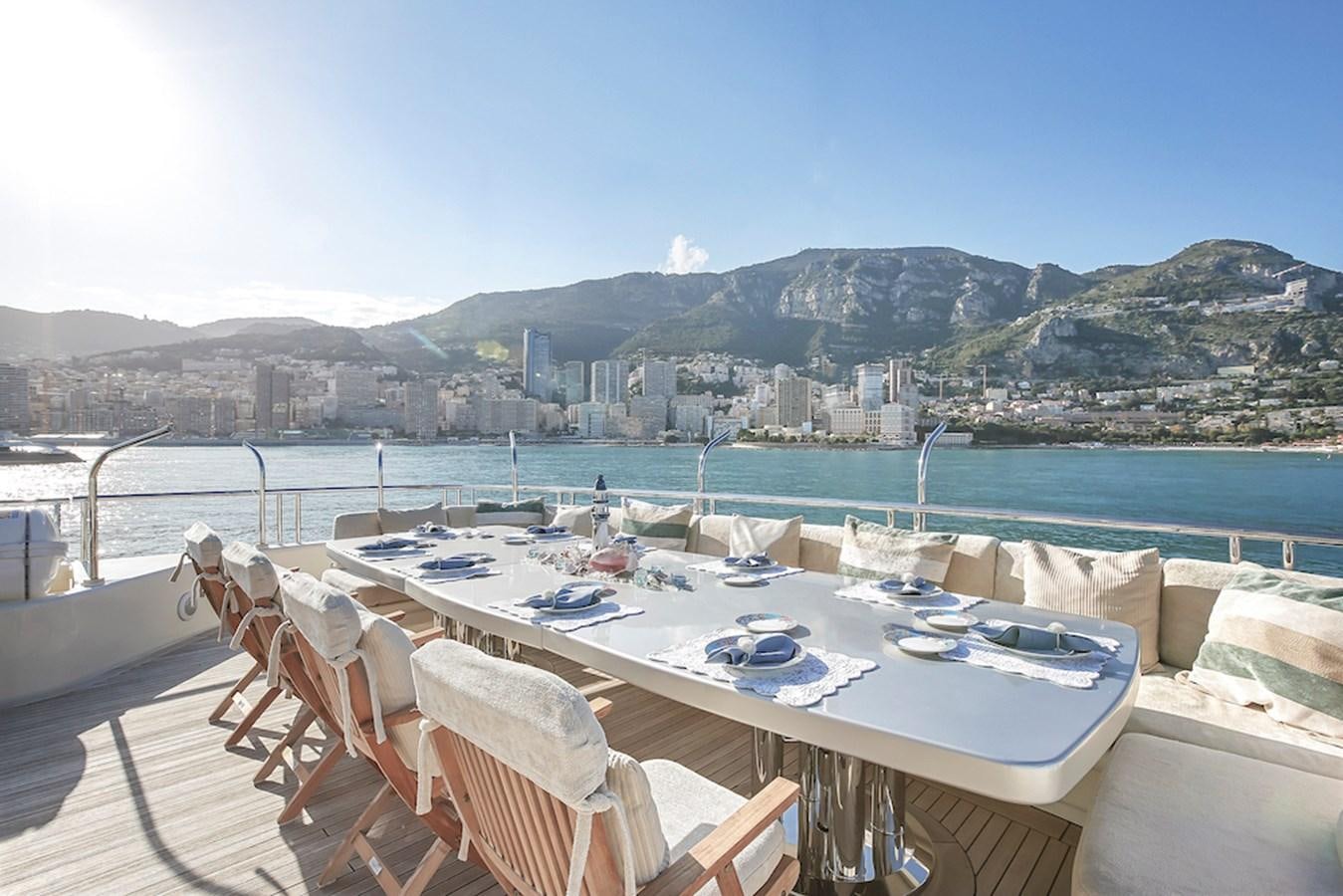 a table with chairs on it next to a body of water aboard SAMIRA Yacht for Sale
