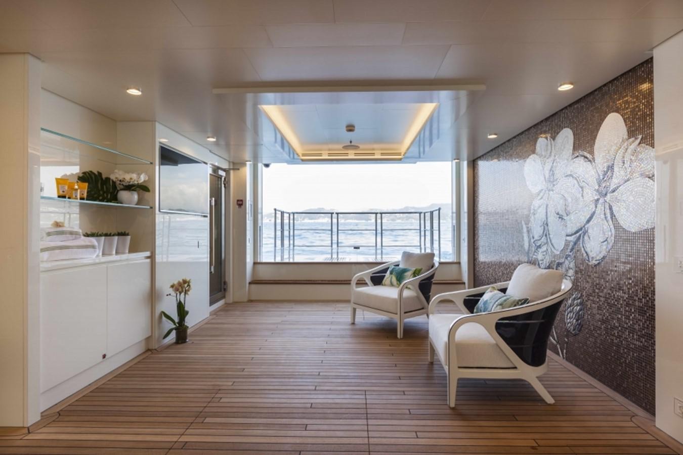 a room with a large window and a wood floor aboard QUINTA ESSENTIA Yacht for Sale