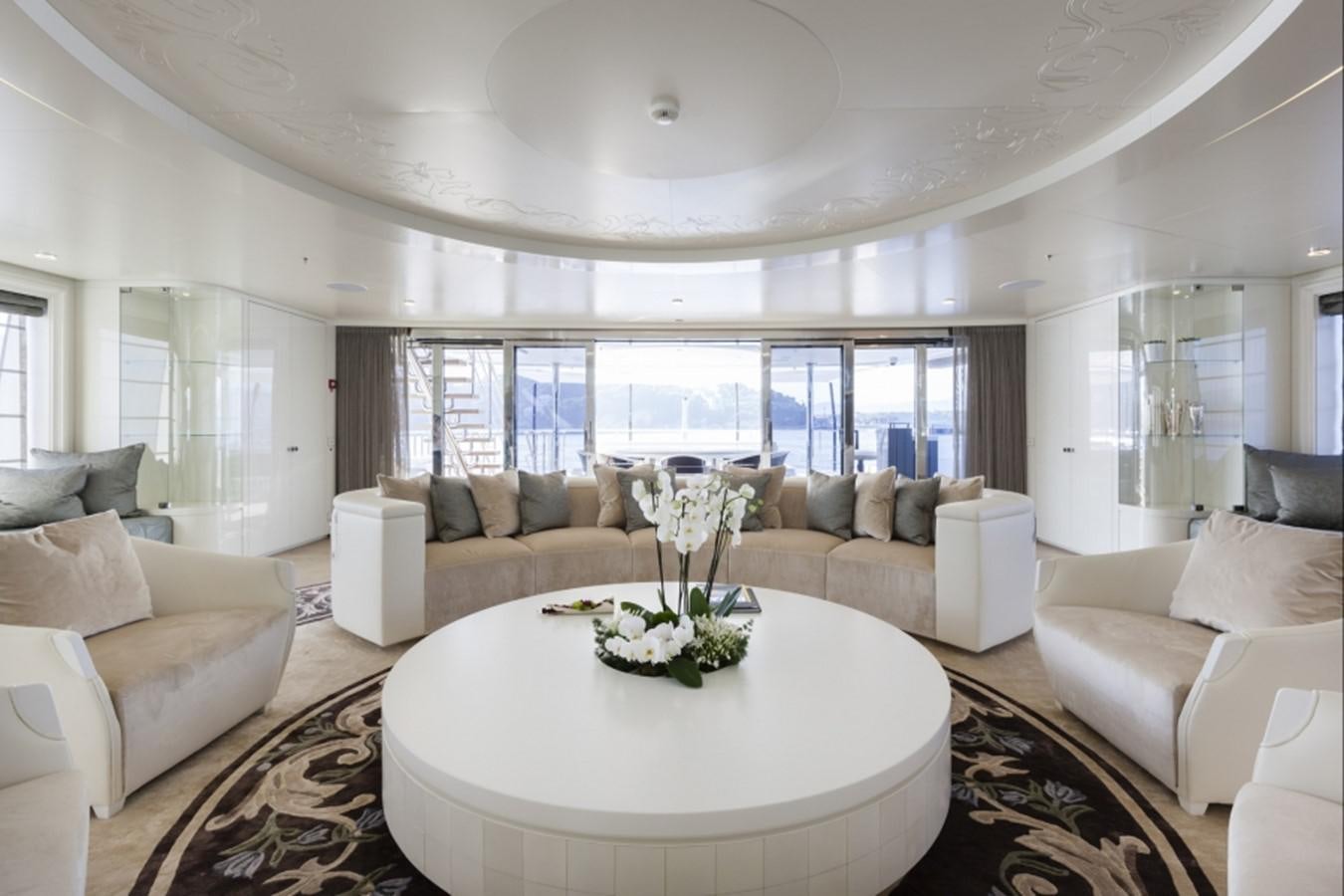 a living room with a large white table and white couches aboard QUINTA ESSENTIA Yacht for Sale