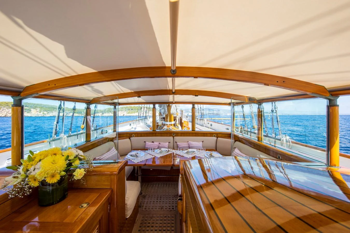 a room with a bed and a table with flowers aboard SHENANDOAH OF SARK Yacht for Charter