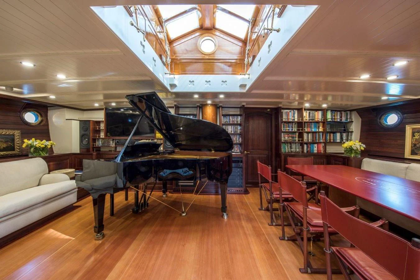 a room with a piano and chairs aboard SHENANDOAH OF SARK Yacht for Charter