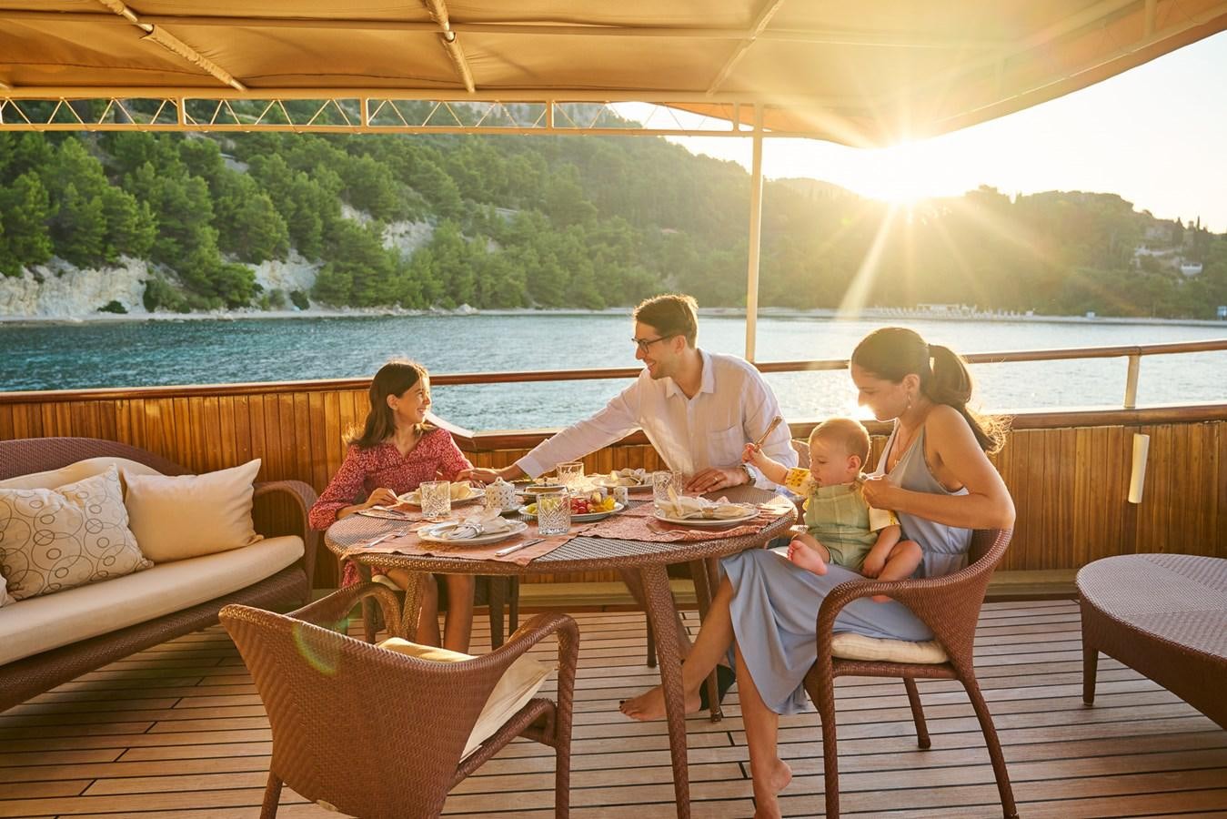a family sits around a table aboard SEAGULL II Yacht for Sale