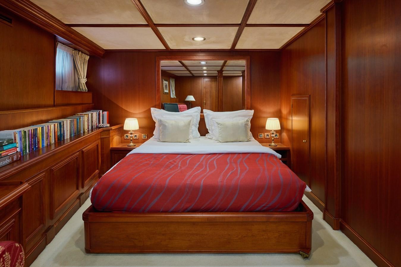 a bed with a red and purple comforter and pillows aboard SEAGULL II Yacht for Sale