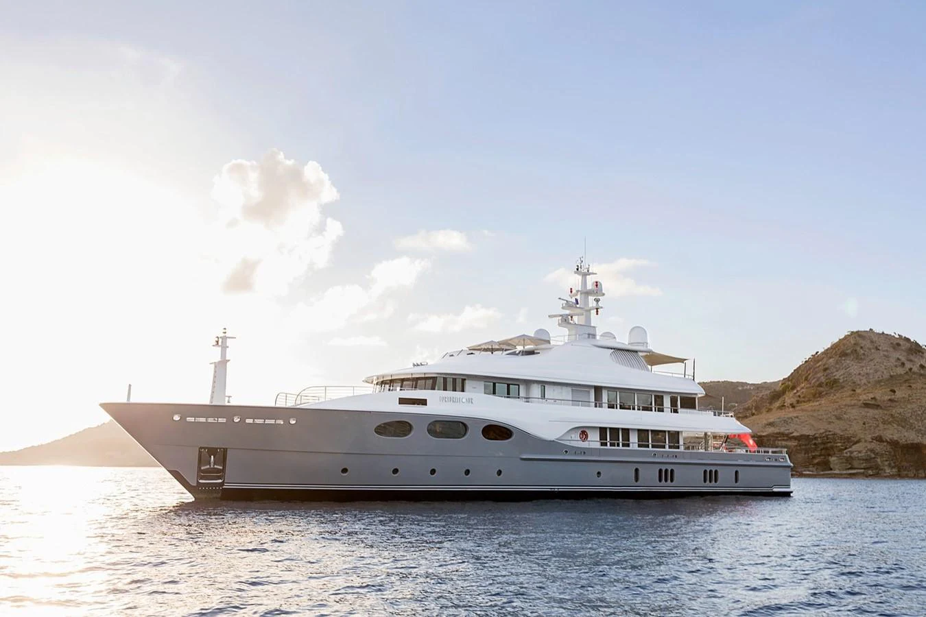 a white yacht on the water aboard FORTUNATE SUN Yacht for Sale