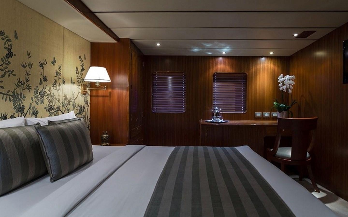 a bed with a white sheet and a black and white striped bed spread aboard NORTHERN SUN Yacht for Sale