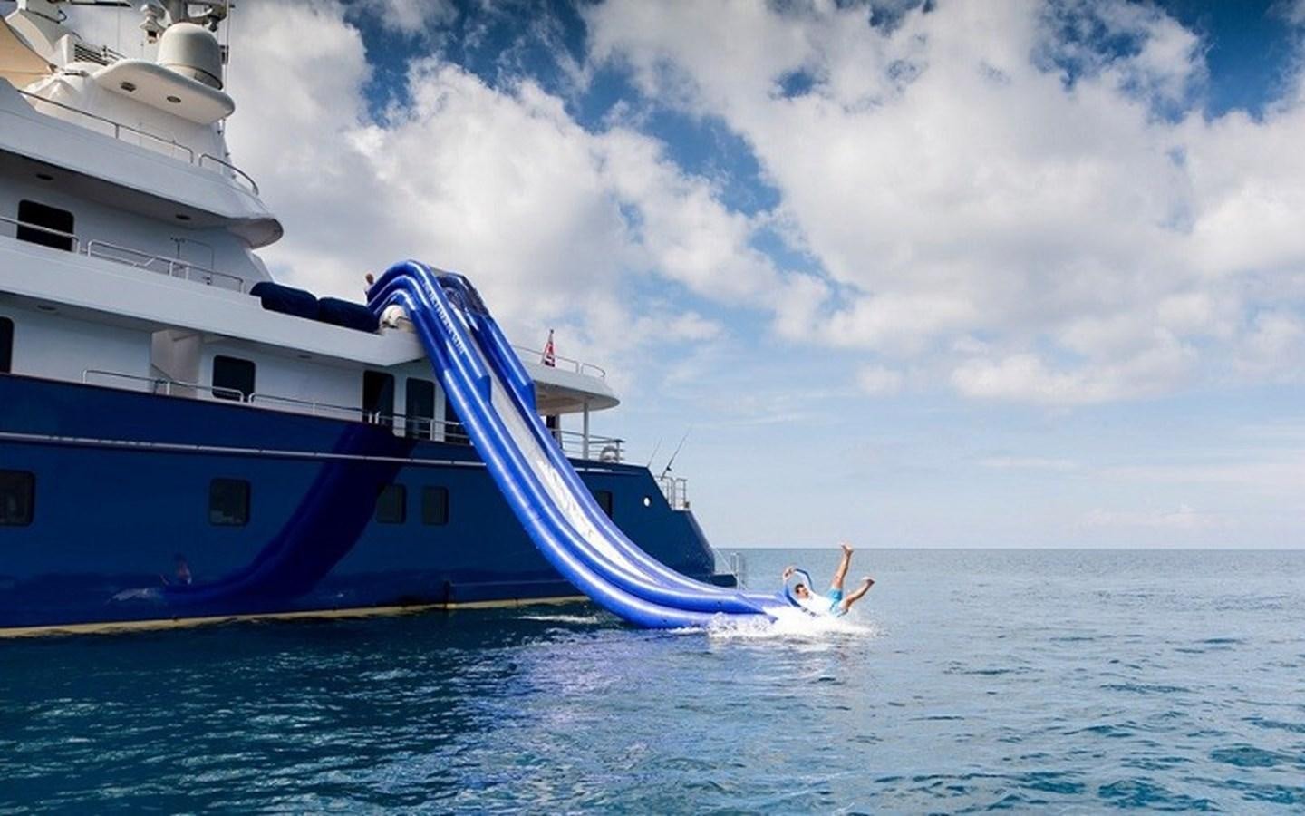 a person swimming in the water next to a large boat aboard NORTHERN SUN Yacht for Sale