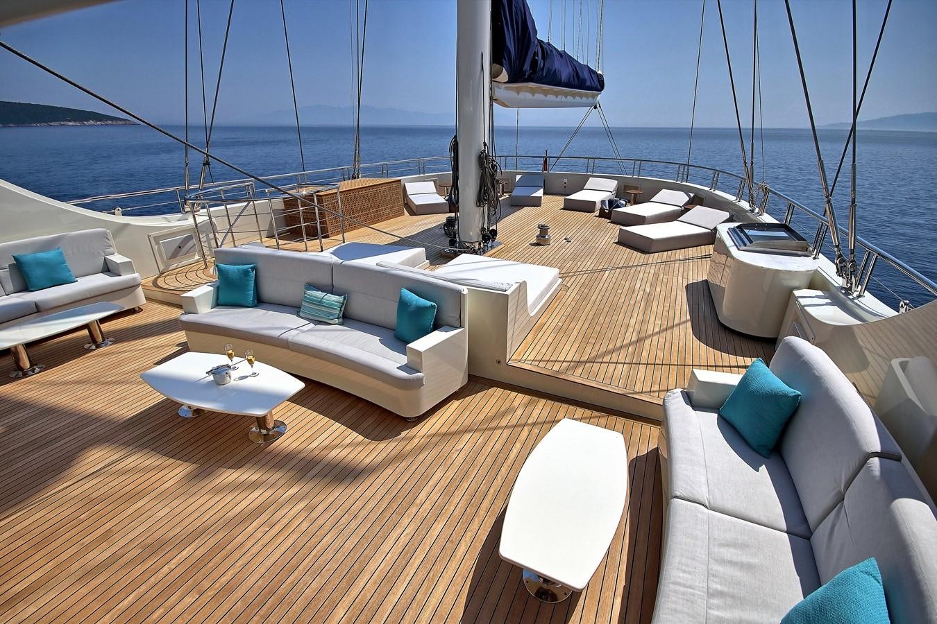 a room with a couch and a table on a deck aboard MEIRA Yacht for Sale