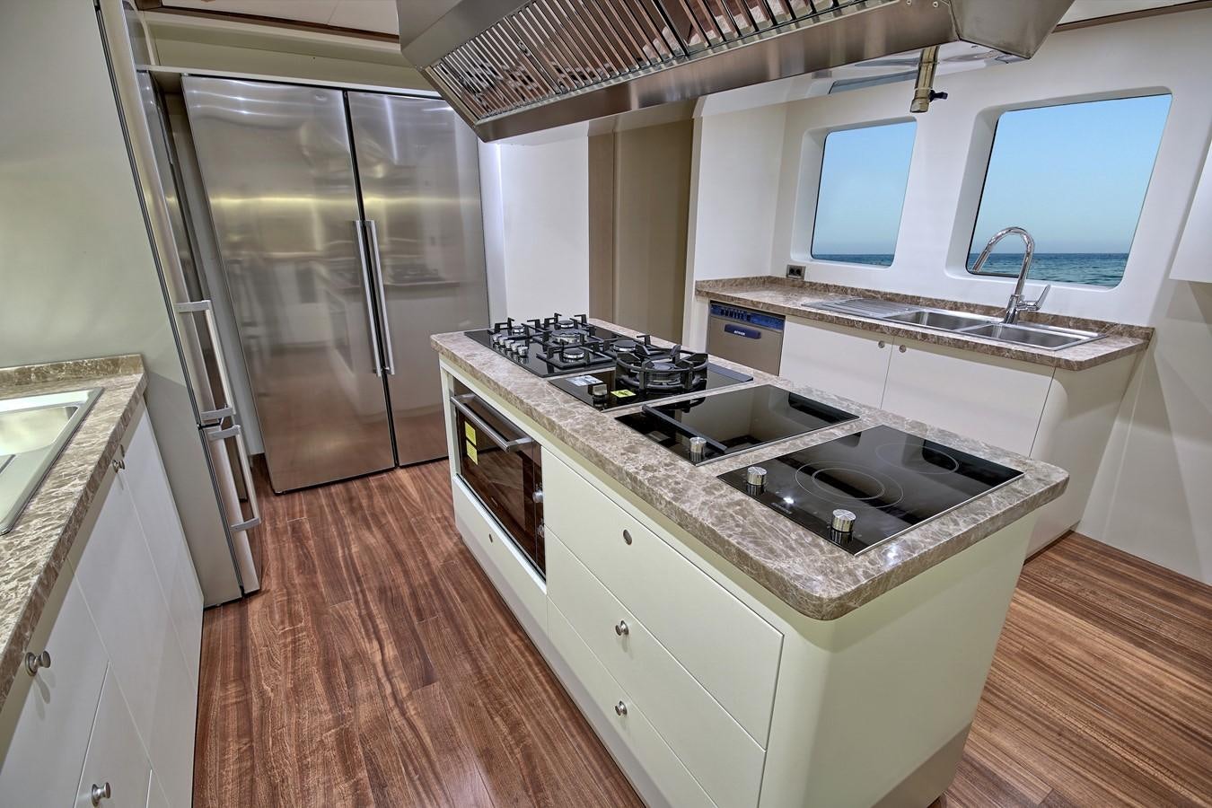 a kitchen with a stove and refrigerator aboard MEIRA Yacht for Sale