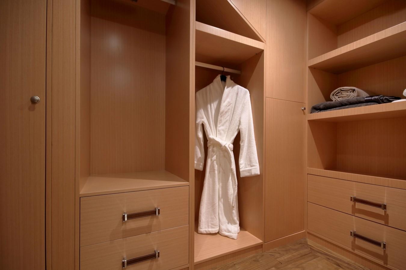 a closet with a white dress on the wall aboard MEIRA Yacht for Sale