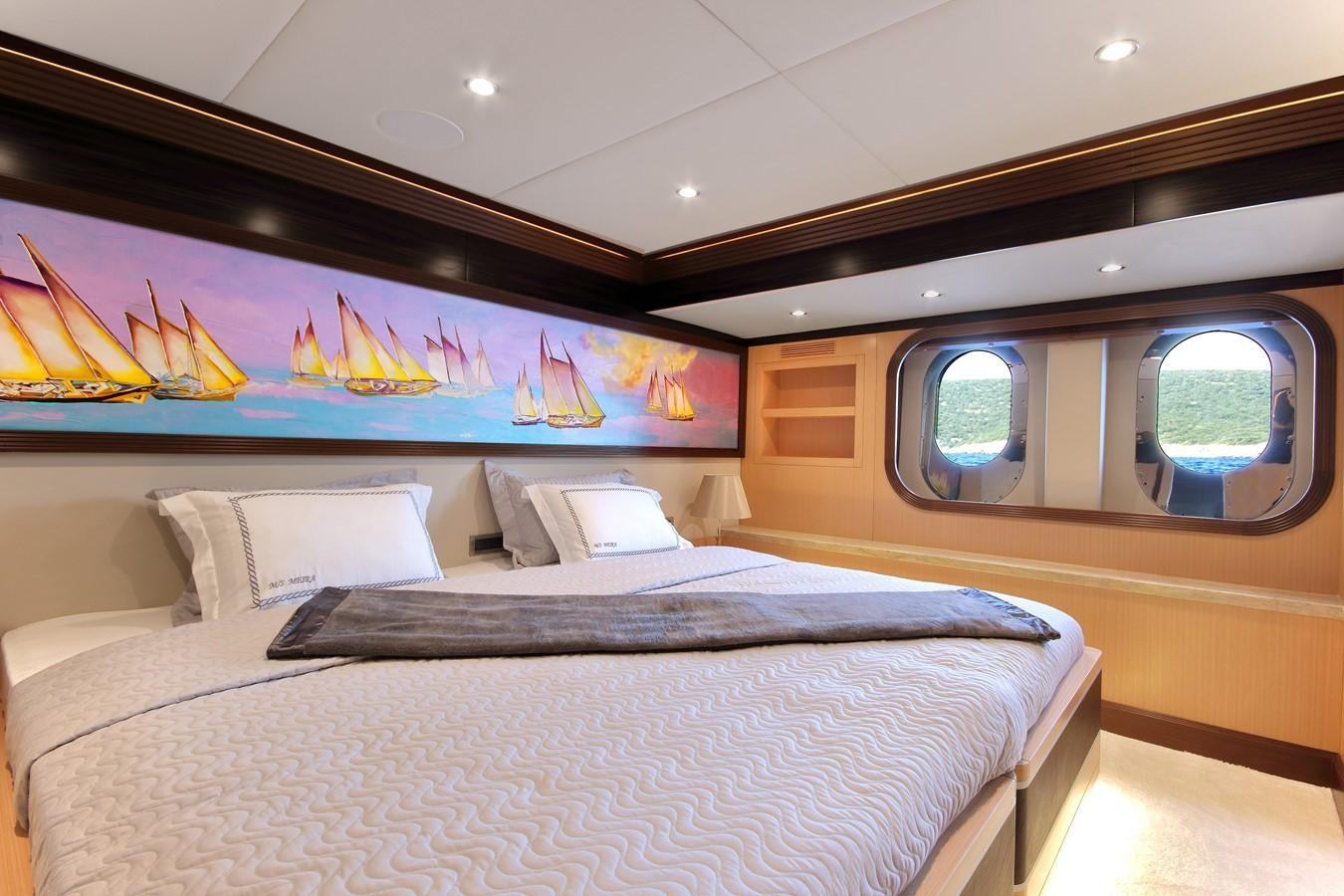 a bed with a blue wall aboard MEIRA Yacht for Sale