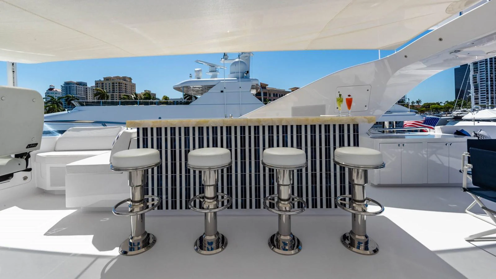 a row of stools on a white surface in front of a window aboard APRICITY Yacht for Sale