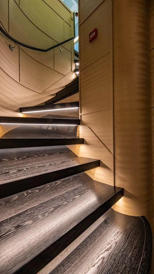 a wooden staircase with metal railings aboard APRICITY Yacht for Sale
