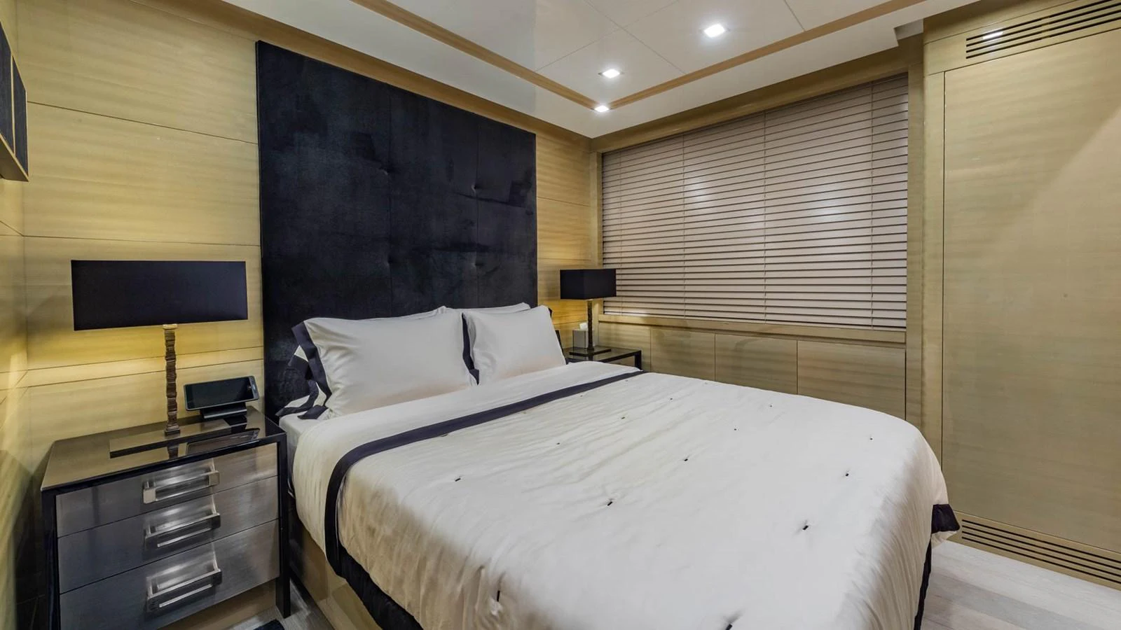 a bed with a white sheet and pillows in a room with a television aboard APRICITY Yacht for Sale