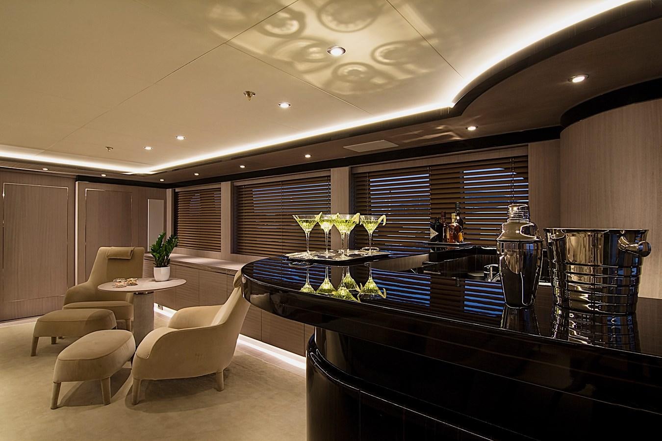 a large room with a bar and chairs aboard INVADER Yacht for Sale