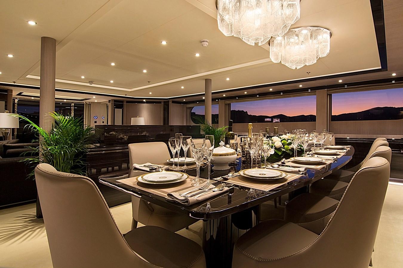 a dining room with a table set for a formal dinner aboard INVADER Yacht for Sale