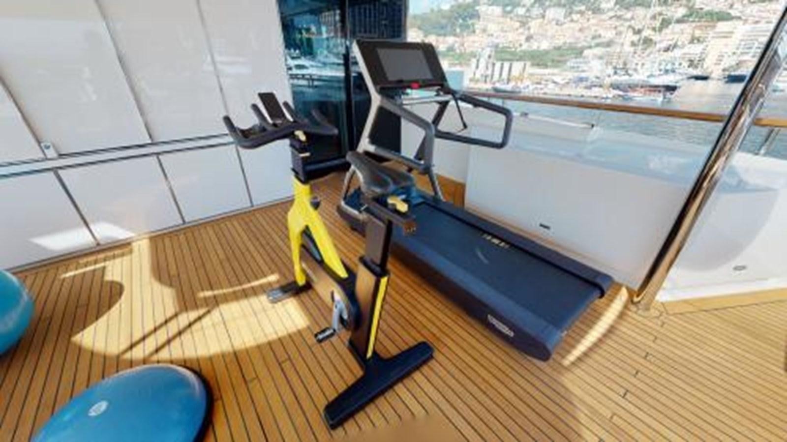 a black and yellow tripod on a wooden floor next to a window aboard LA PELLEGRINA 1 Yacht for Sale