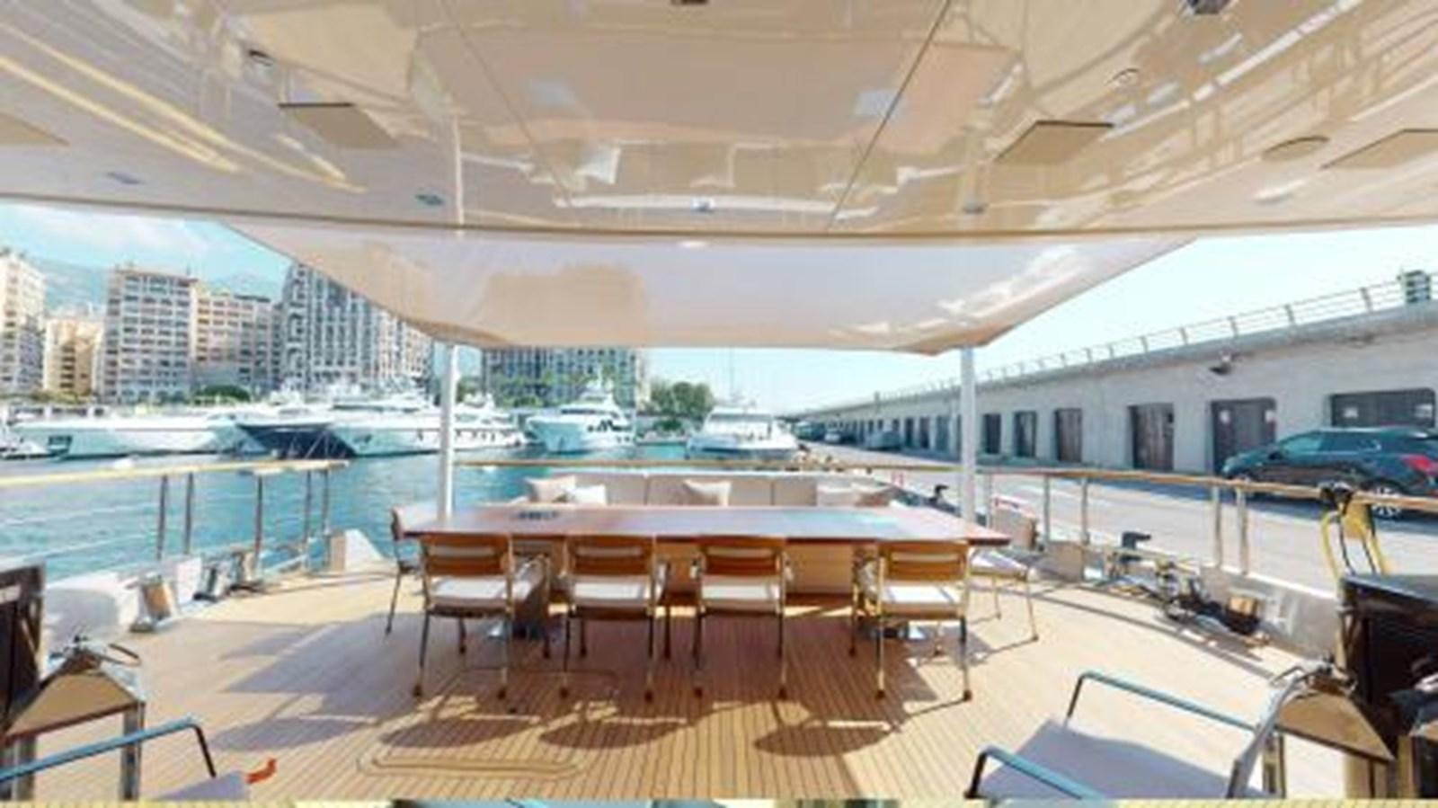 a large lounge area with a pool and a city in the background aboard LA PELLEGRINA 1 Yacht for Sale