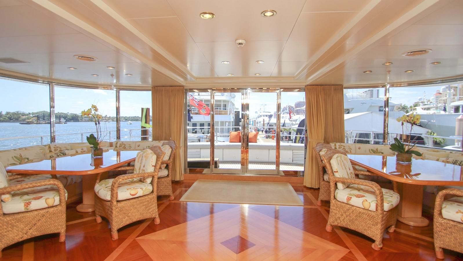 a large living room with a wood floor and a large window aboard TE MANU Yacht for Sale