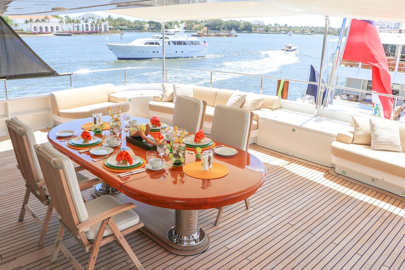 a table set for a meal on a deck overlooking a large body of water aboard TE MANU Yacht for Sale