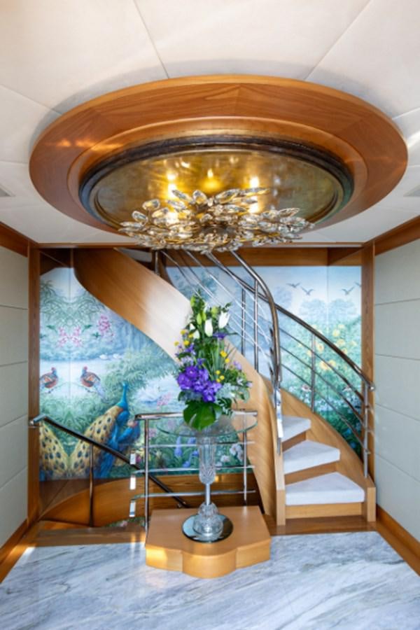 a staircase with a glass vase with flowers on it aboard VIBRANCE Yacht for Sale