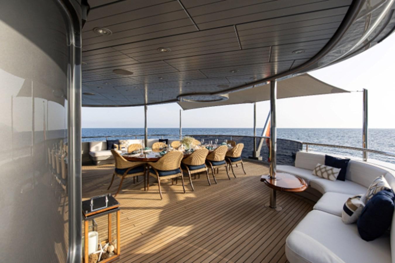a large room with a table and chairs on the deck aboard VIBRANCE Yacht for Sale