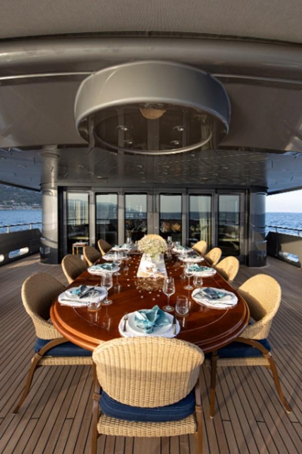 a dining room table with a chandelier above it aboard VIBRANCE Yacht for Sale