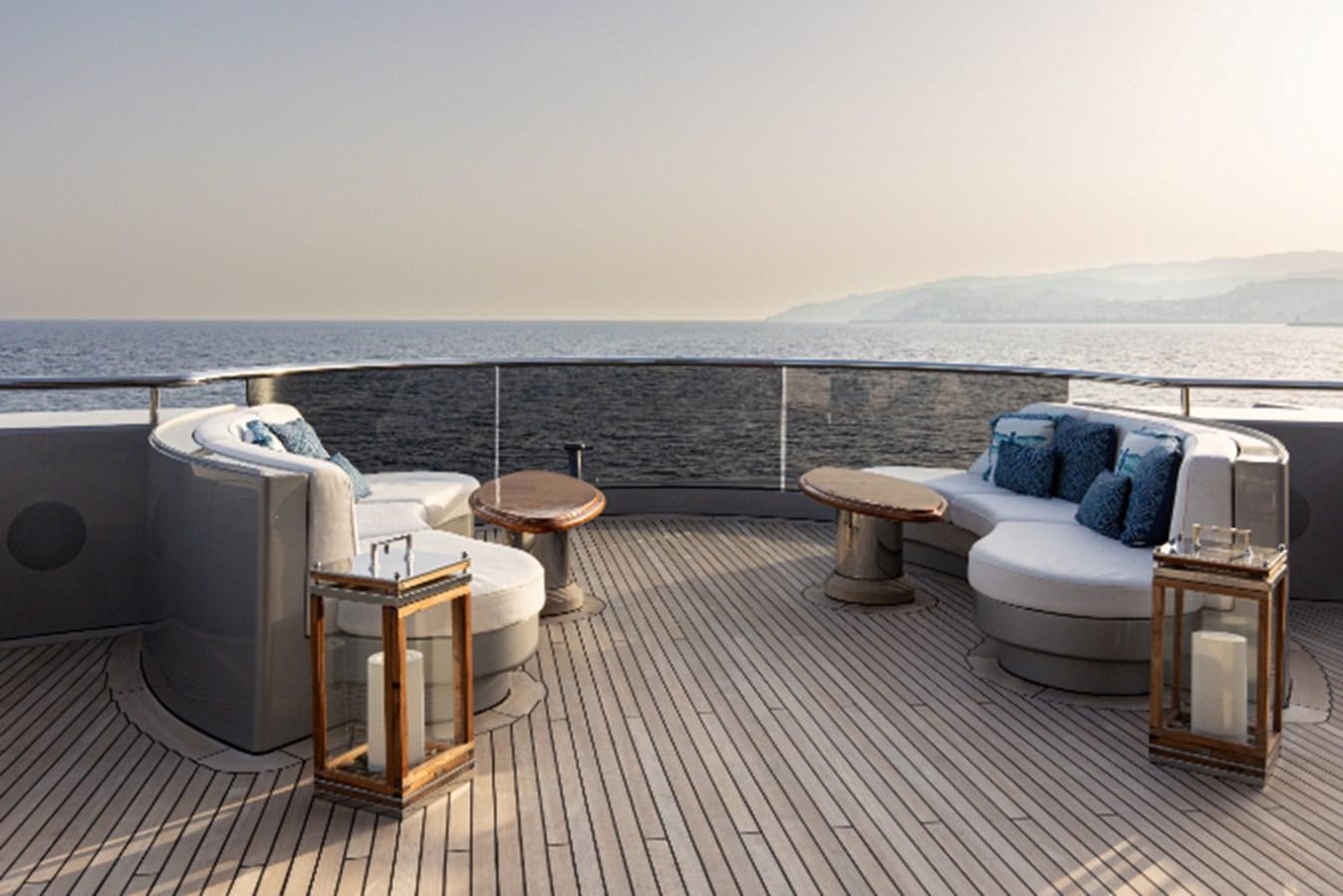 a large white lounge chair on a deck overlooking a large body of water aboard VIBRANCE Yacht for Sale