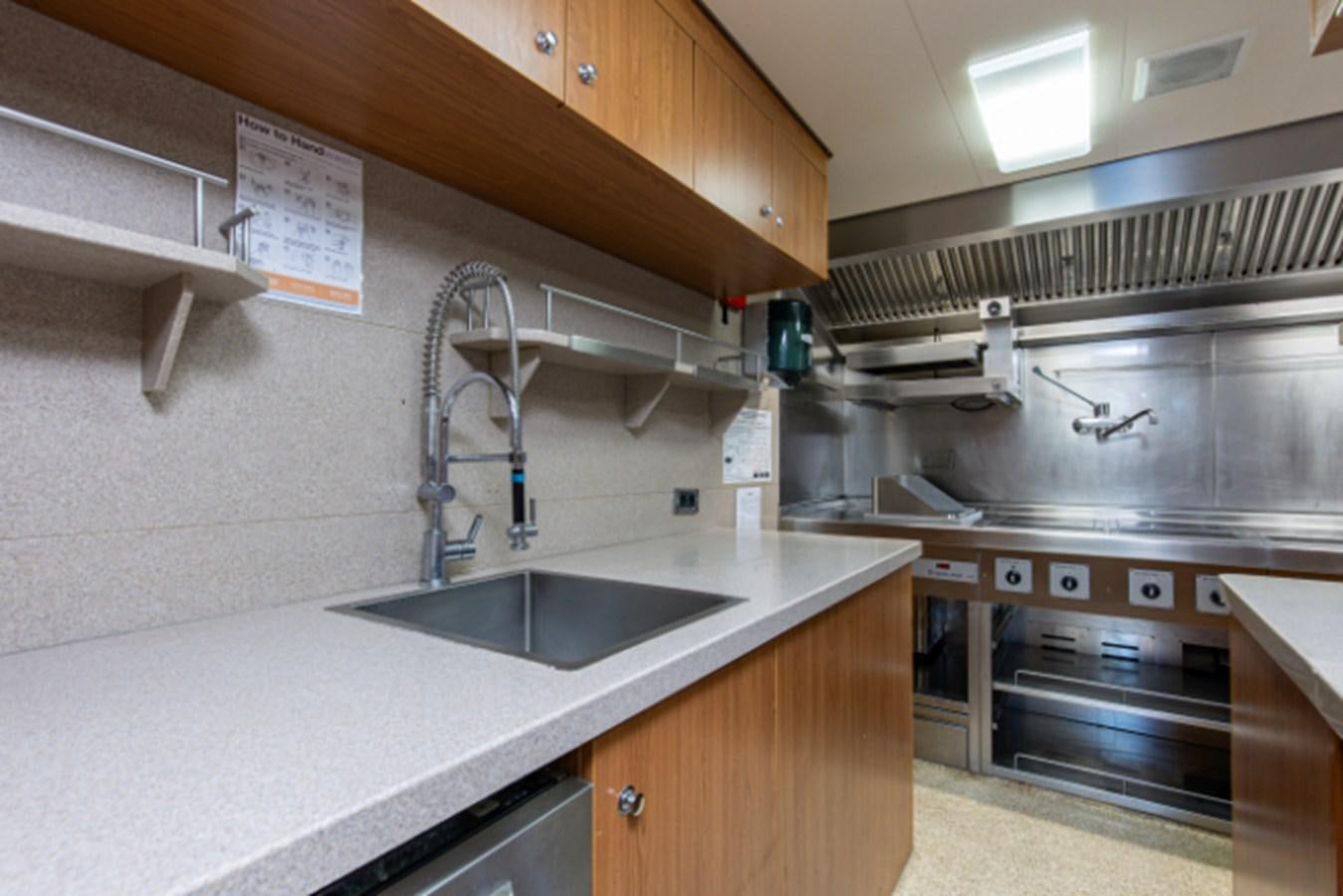 a kitchen with a sink and a stove aboard VIBRANCE Yacht for Sale