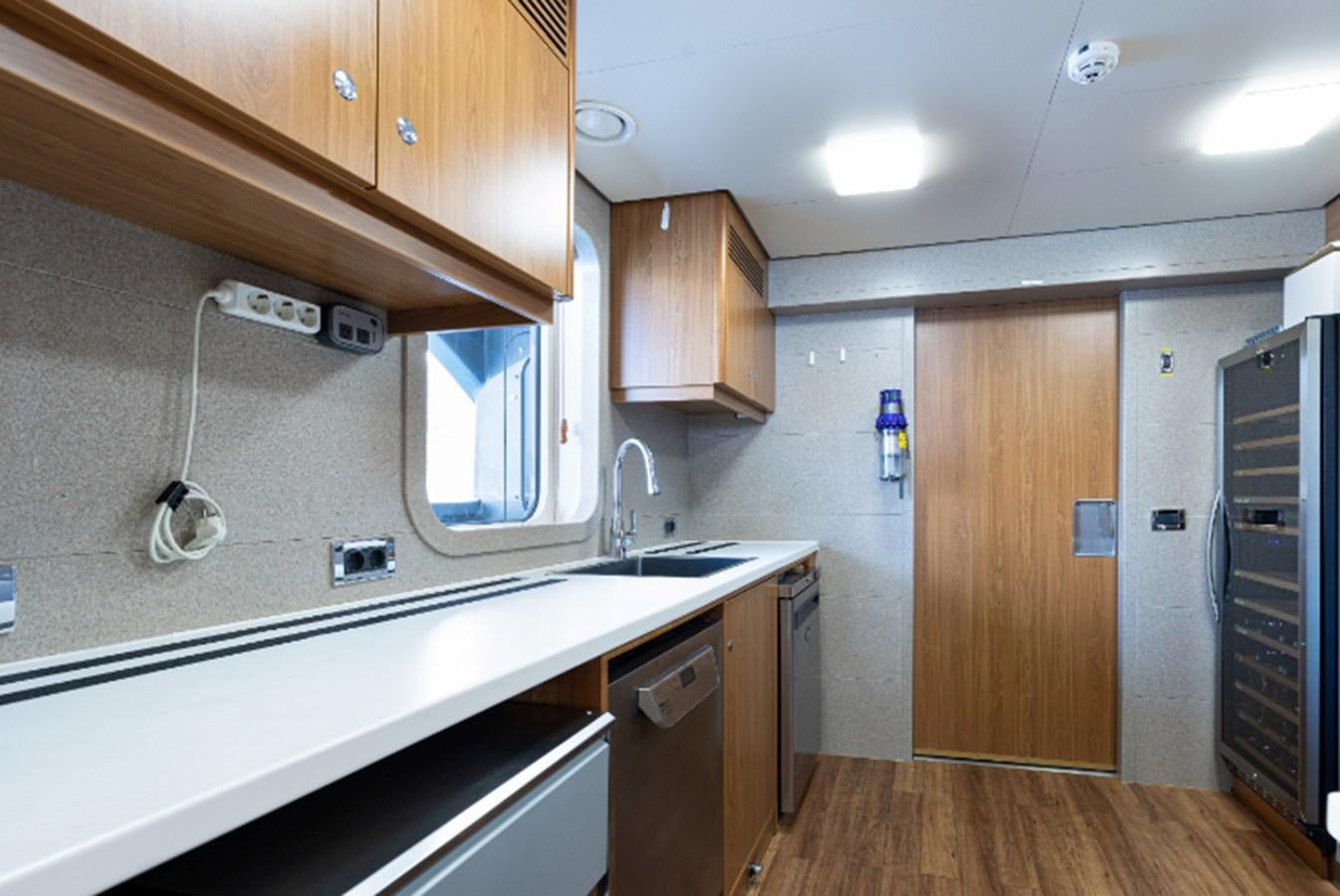 a kitchen with wooden cabinets aboard VIBRANCE Yacht for Sale