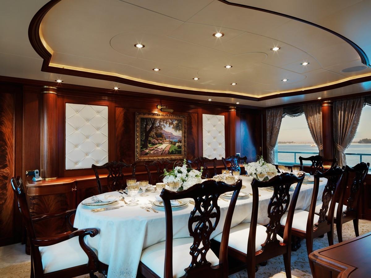 a dining room with a table set for a formal dinner aboard AQUAMARINA Yacht for Sale