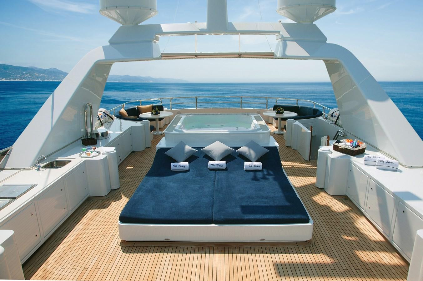 a deck with a pool and a deck with chairs and tables aboard VA BENE Yacht for Sale
