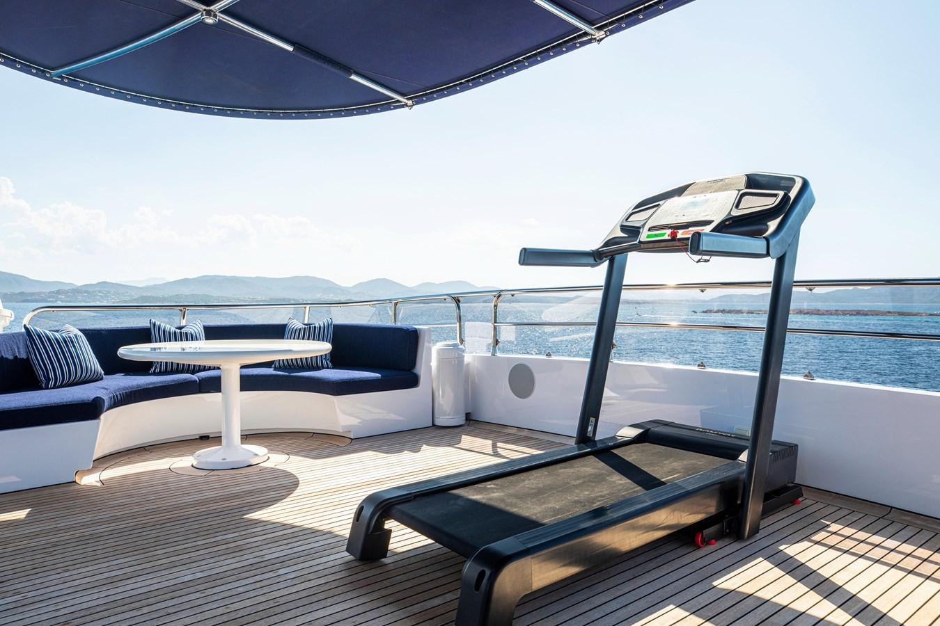 a lounge chair on a deck overlooking a body of water aboard VA BENE Yacht for Sale