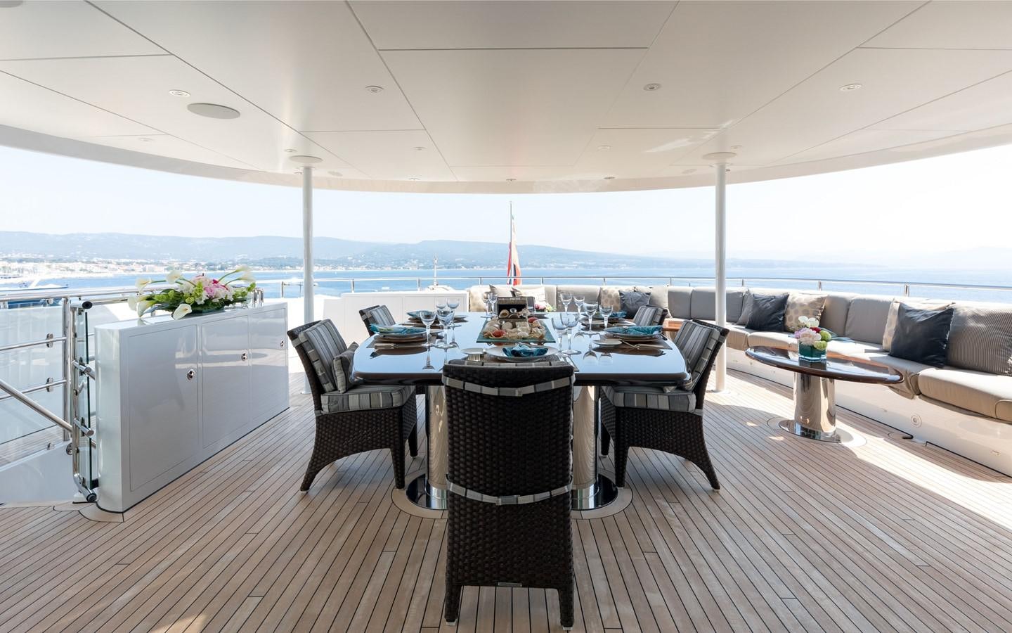 a large room with a table and chairs aboard ATINA Yacht for Sale
