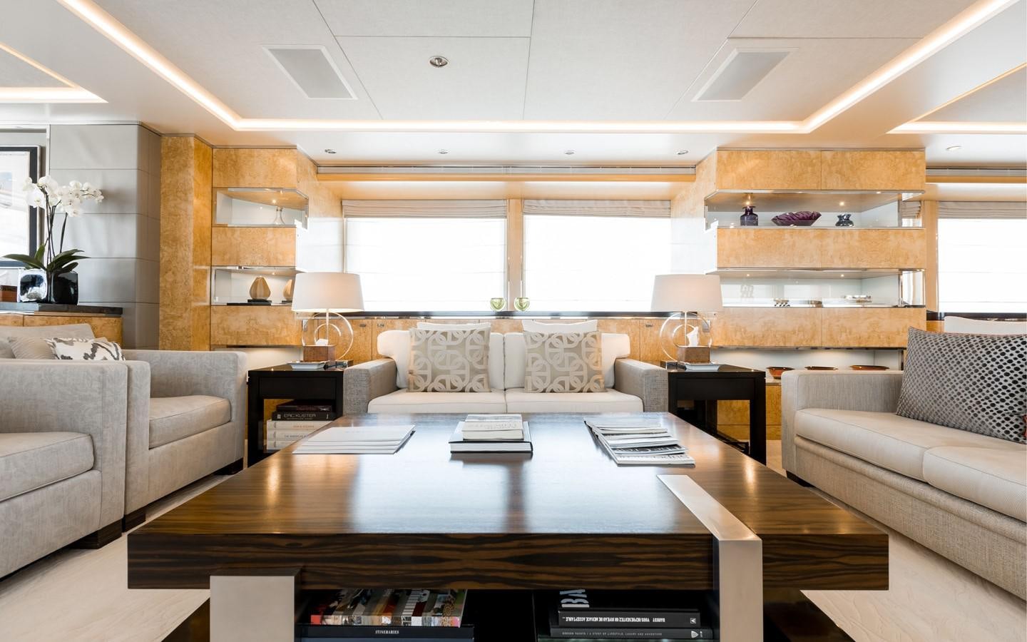 a large living room with a large table and couches aboard ATINA Yacht for Sale