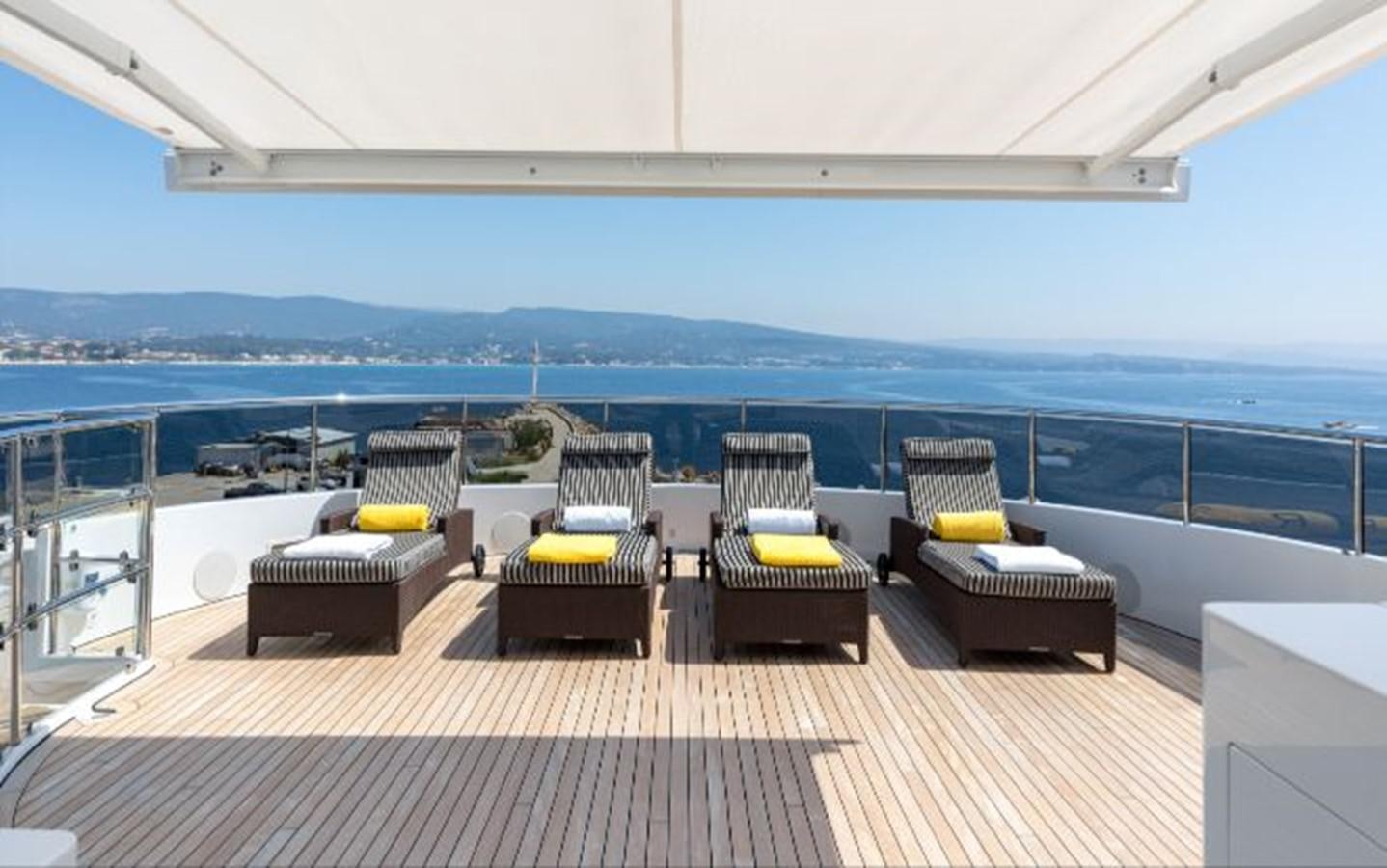 a deck with chairs and a table aboard ATINA Yacht for Sale