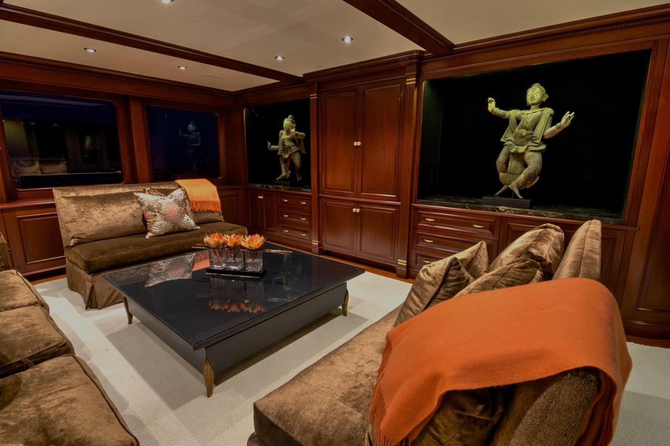 a living room with a large wood cabinet and a round coffee table aboard SCORPIO Yacht for Sale