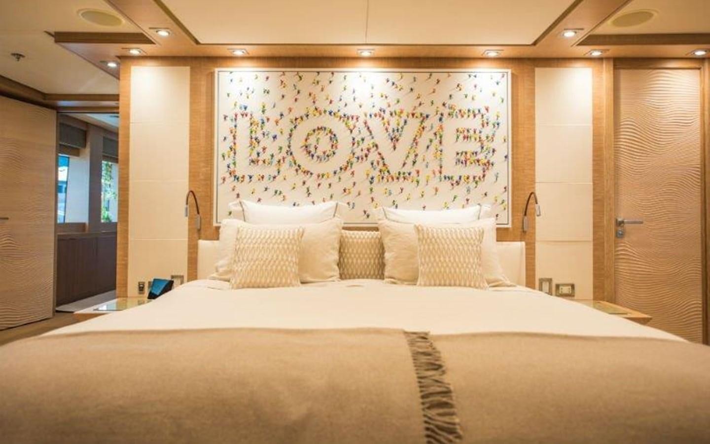 a large bed with a painting on the wall aboard NORMA JEAN Yacht for Sale