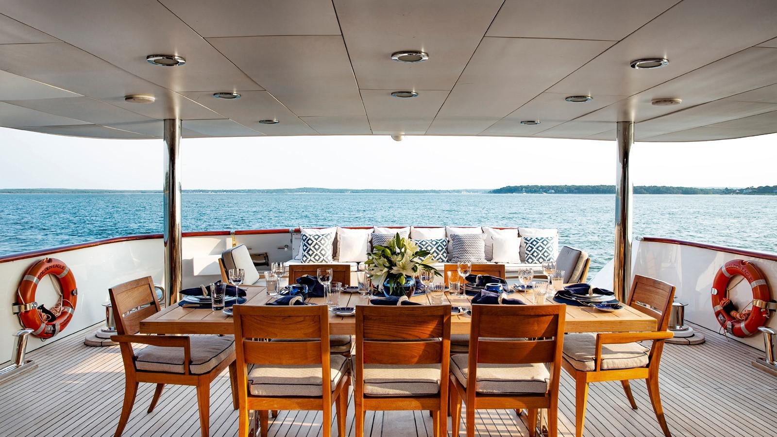 a table with chairs and a view of the ocean aboard NATALIA V Yacht for Sale