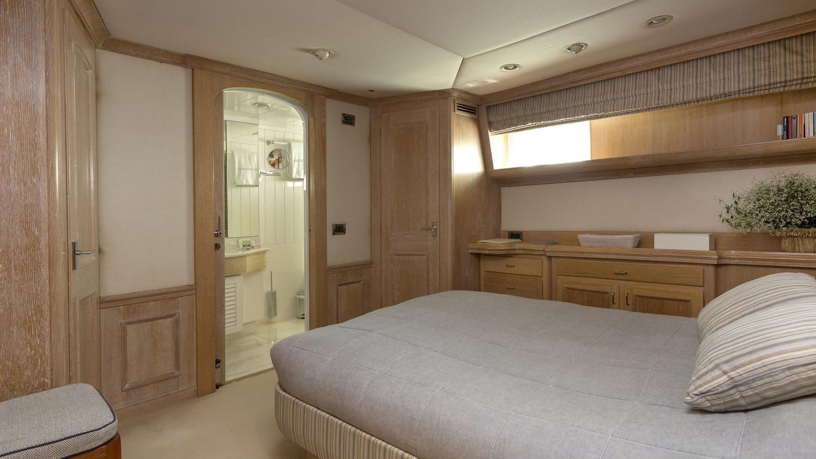 a bedroom with a bed and a desk aboard NATALIA V Yacht for Sale