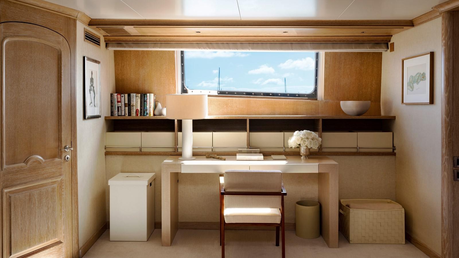 a room with a tv and a shelf with books aboard NATALIA V Yacht for Sale