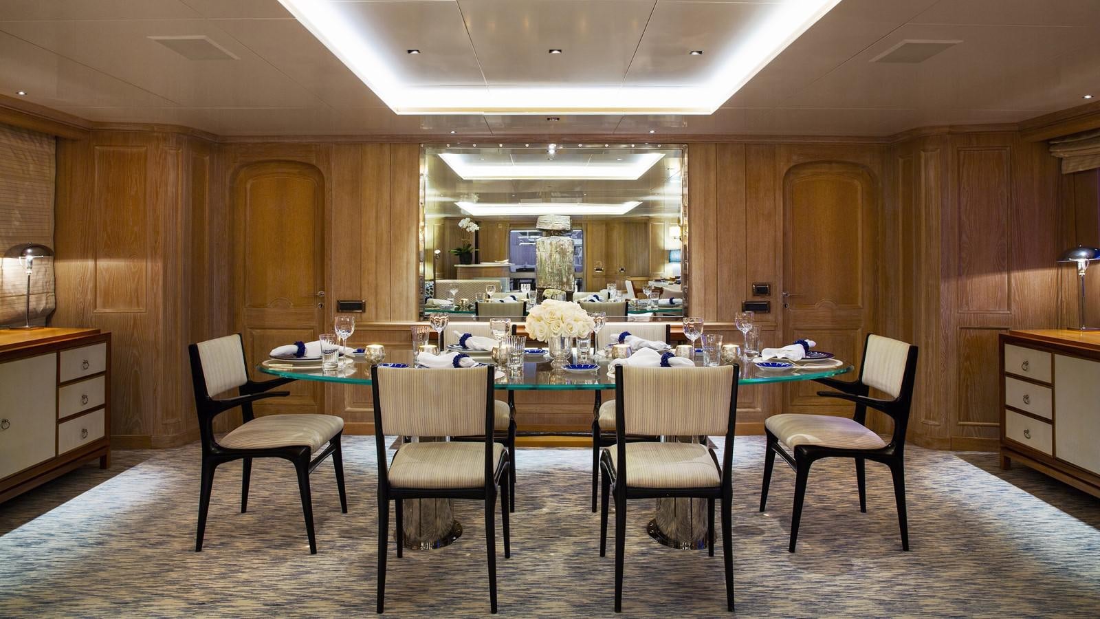 a dining table and chairs in a room with wood walls aboard NATALIA V Yacht for Sale