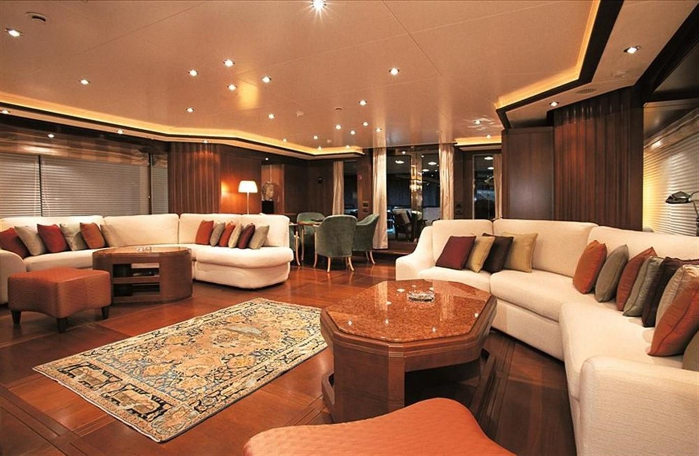a living room with a table and couches aboard MORE Yacht for Sale
