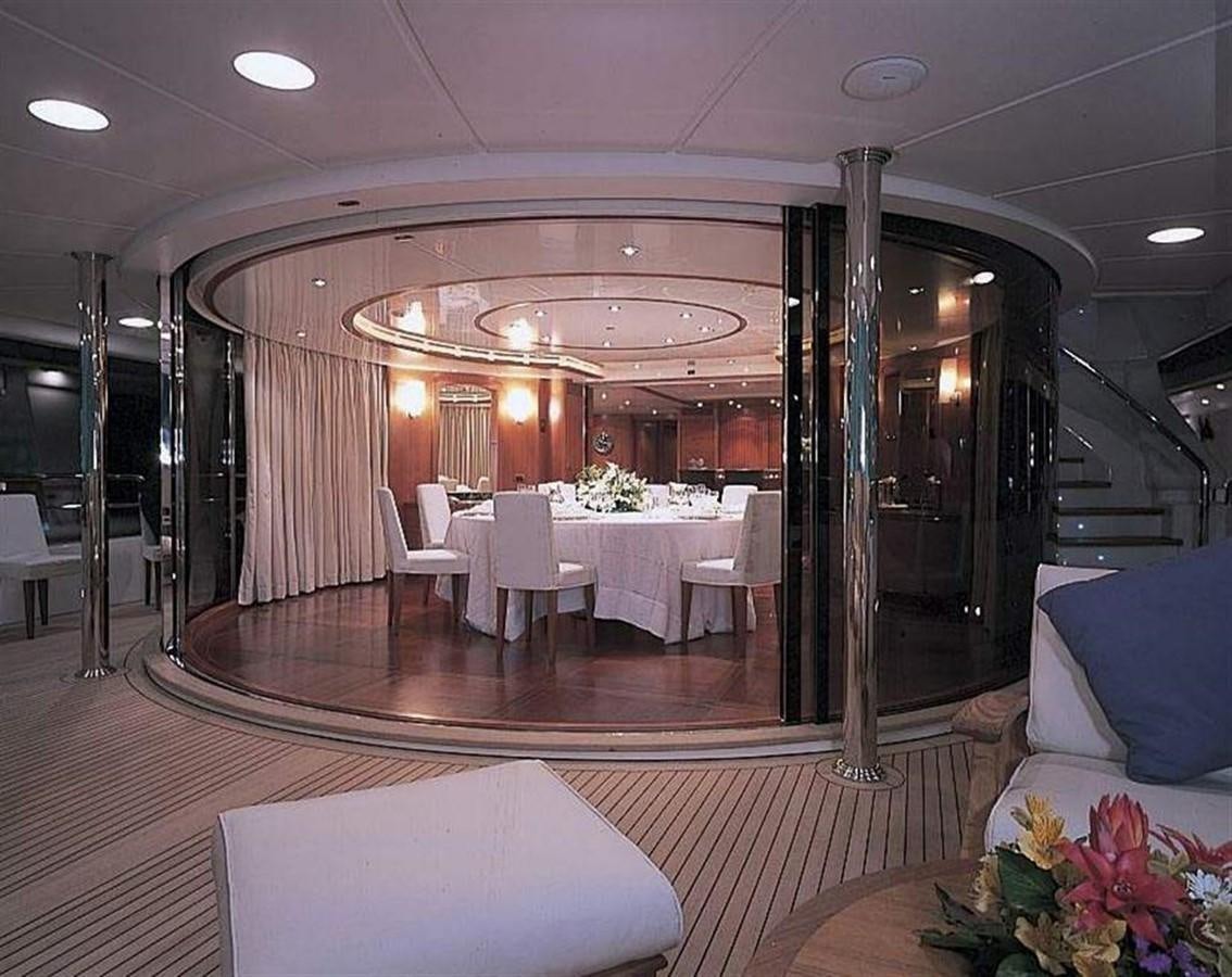 a room with tables and chairs aboard MORE Yacht for Sale