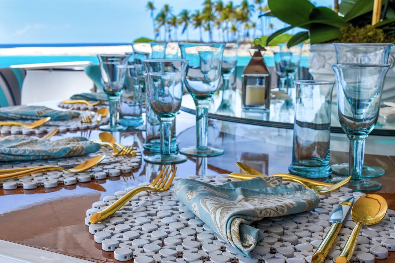 a table with many glasses and plates aboard OCTOPUSSY Yacht for Sale